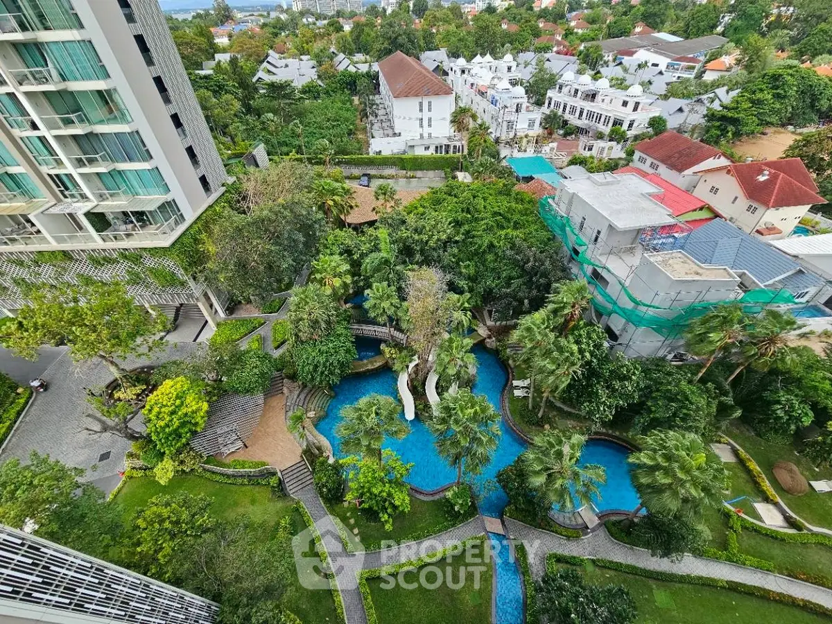 Stunning aerial view of lush garden and pool in upscale residential complex.