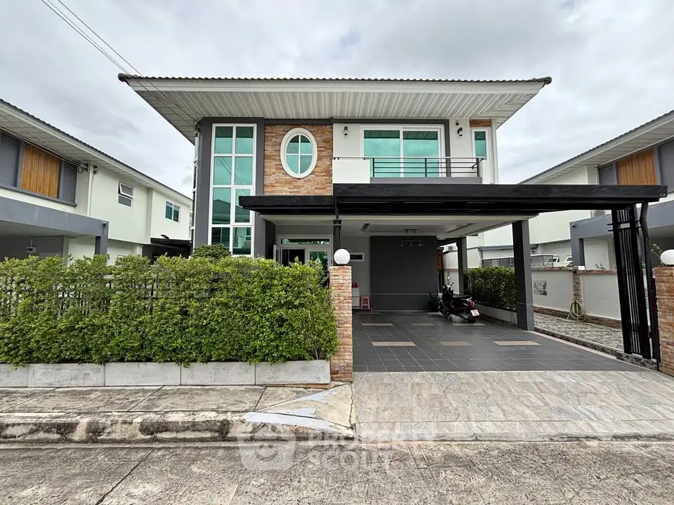 Modern two-story house with spacious driveway and lush greenery