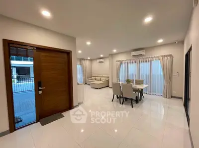 Spacious modern living room with elegant dining area and large windows for natural light.