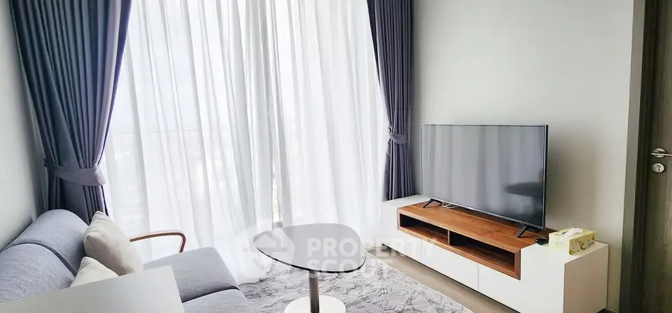 Modern living room with stylish furniture and large window drapes