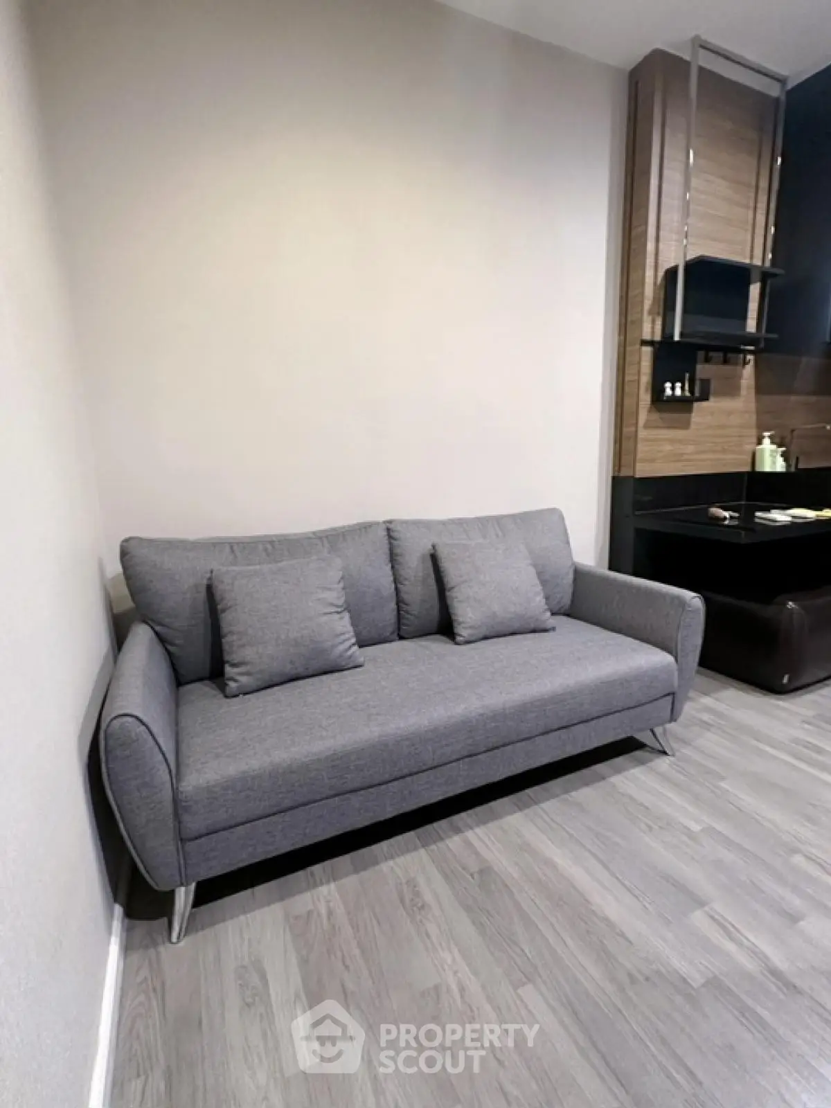 Modern living room with sleek gray sofa and stylish wooden accents