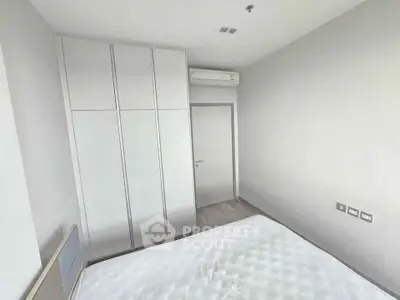 Spacious bedroom with modern wardrobe and air conditioning in a minimalist design.