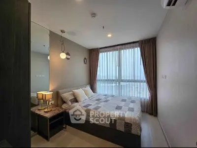 Cozy bedroom with modern decor and large window offering natural light.