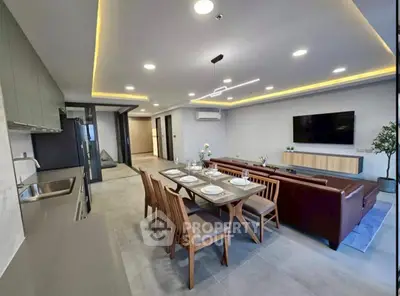 Spacious modern living room with open kitchen, elegant dining area, and stylish lighting.