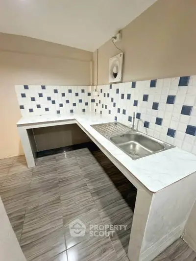 Modern kitchen with stylish tile backsplash and sleek countertops