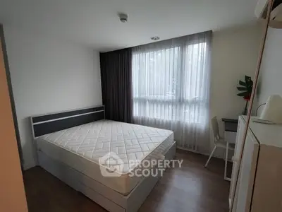 Cozy bedroom with large window and minimalist decor, perfect for relaxation.