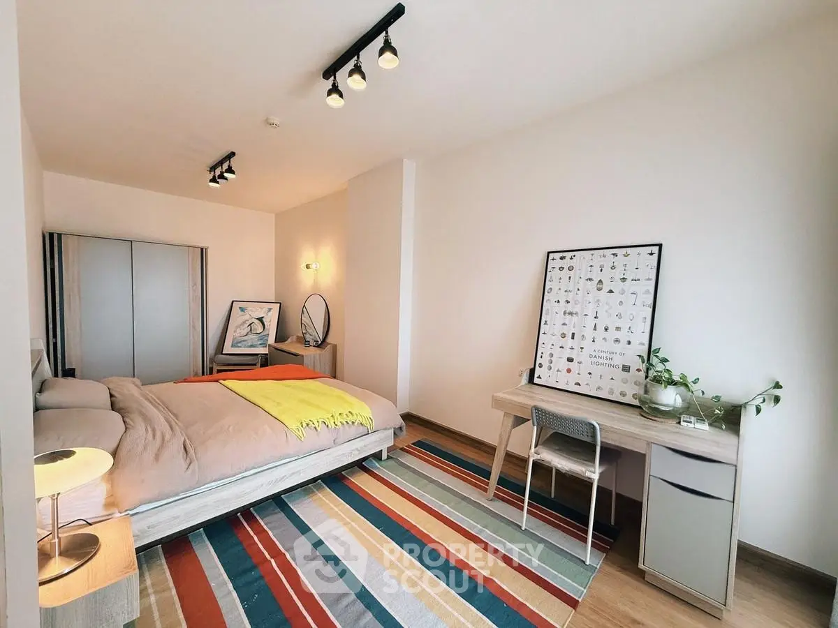 Modern bedroom with stylish decor and colorful striped rug