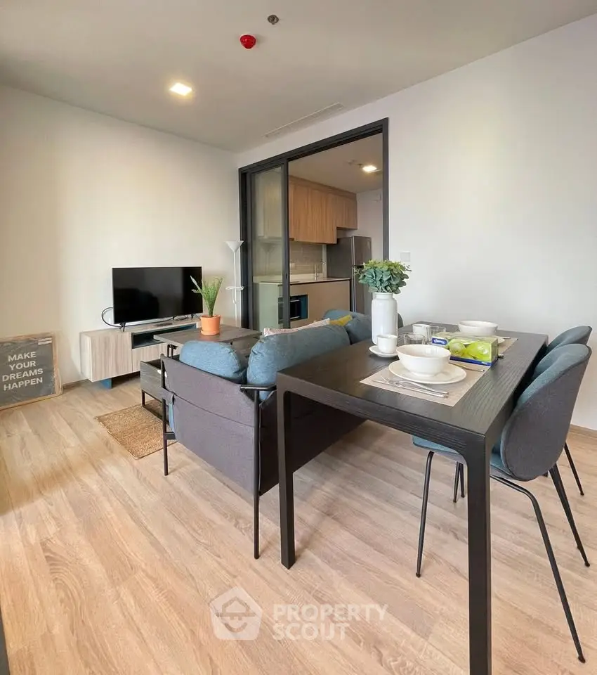 Modern living room with open kitchen and stylish dining area in a cozy apartment.