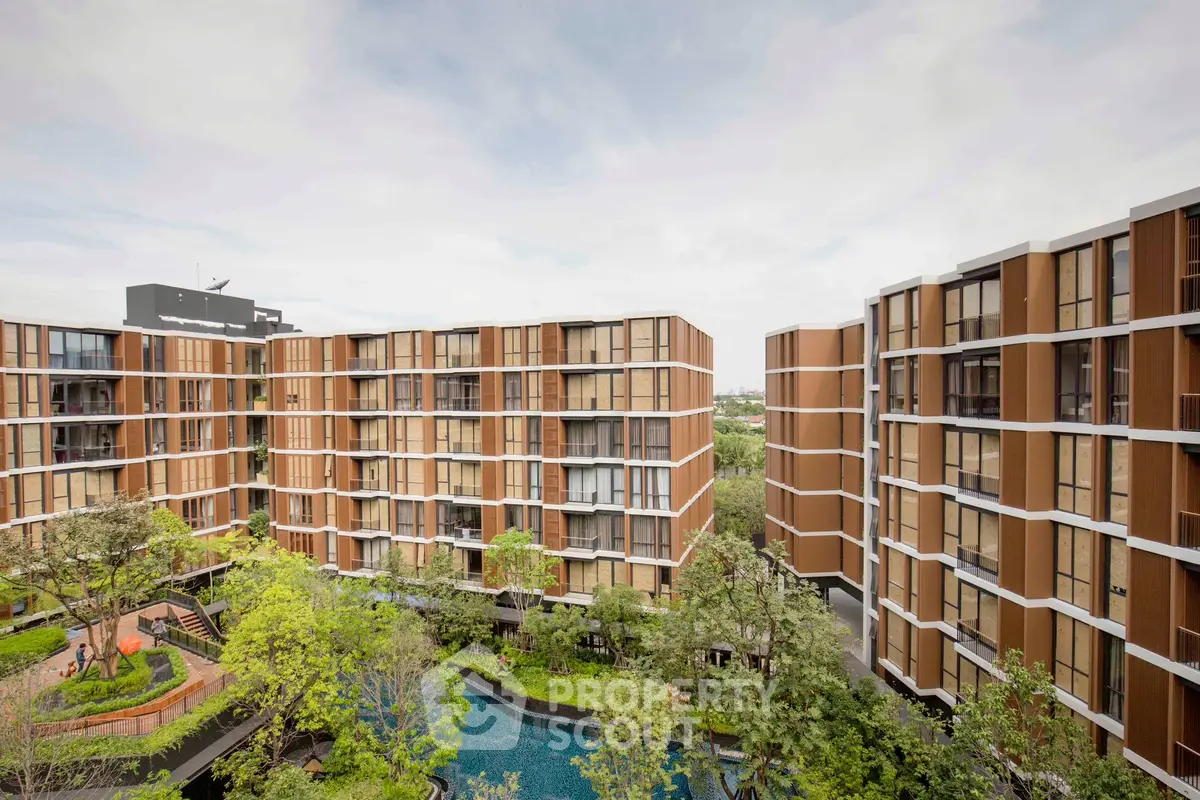 Modern apartment complex with lush greenery and pool view