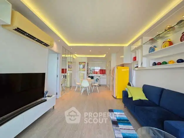Modern living room with vibrant decor and open layout, featuring a yellow fridge and sleek furniture.