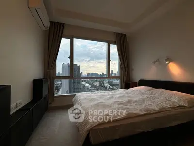 Modern bedroom with large window offering stunning city skyline view, featuring sleek furnishings and ambient lighting.