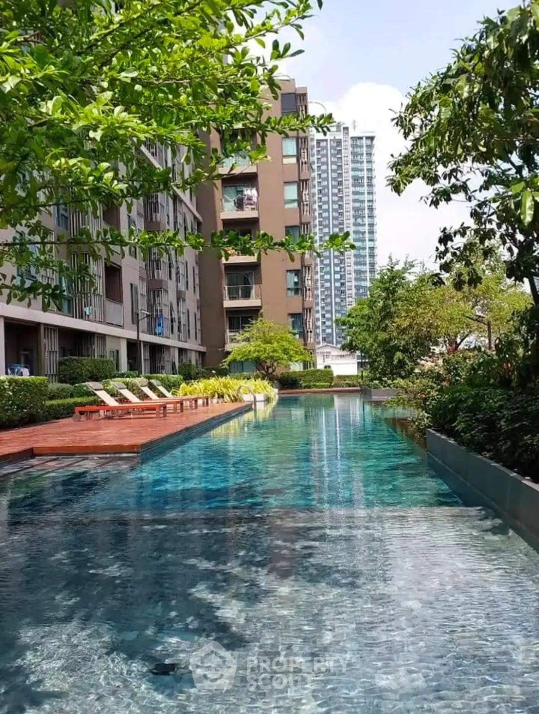 Luxurious apartment complex with stunning outdoor pool and lush greenery