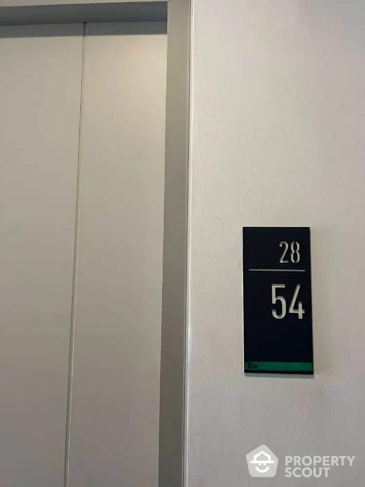 Modern elevator entrance with floor number signage in a residential building.