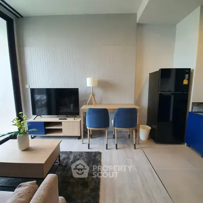 Modern living room with sleek furniture and large TV, featuring a stylish open layout and contemporary design.