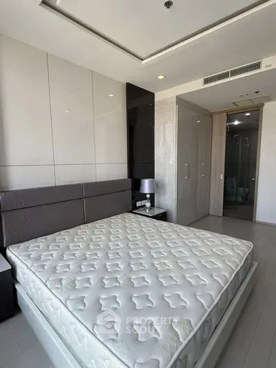 Spacious modern bedroom with elegant design and ample natural light, featuring a large bed and stylish decor.