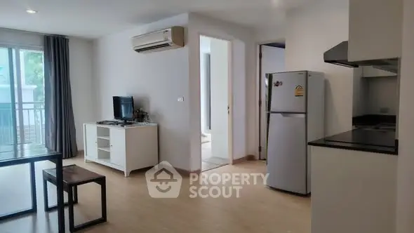 Modern open-plan living room with kitchen and balcony access