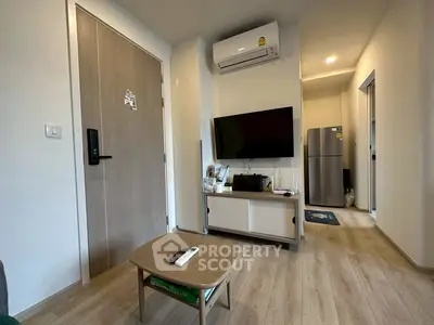 Modern living room with air conditioning and flat-screen TV, featuring sleek wooden flooring and contemporary decor.