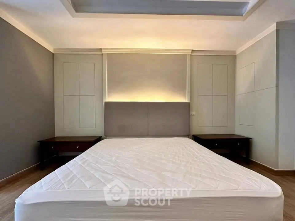 Spacious bedroom with modern design and elegant lighting, featuring a large bed and stylish side tables.