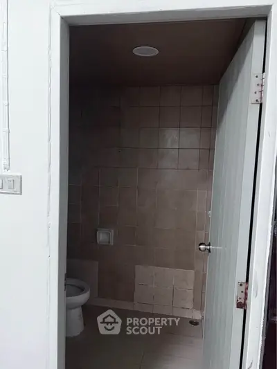 Compact bathroom with tiled walls and a simple design, ideal for minimalist living spaces.
