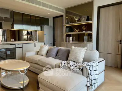 Modern living room with open kitchen, stylish decor, and cozy seating area.