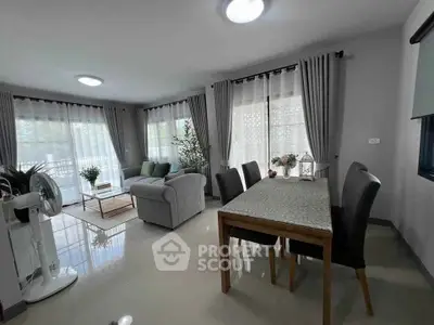 Spacious living and dining area with modern decor and large windows.