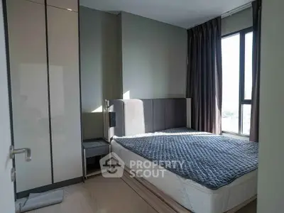 Modern bedroom with large window and sleek wardrobe in a stylish apartment.