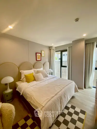 Cozy bedroom with modern decor and natural light, featuring a comfortable bed and stylish furnishings.