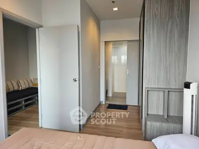Modern bedroom with wooden flooring and sleek design, featuring a cozy bed and ample natural light.