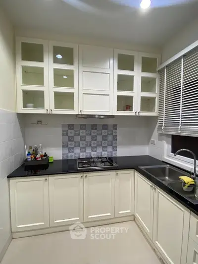 Modern kitchen with sleek cabinetry and gas stove in a cozy apartment