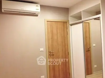 Modern bedroom with air conditioning and mirrored closet doors