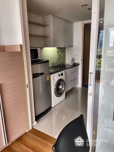 Compact and efficient kitchen space featuring modern appliances, sleek cabinetry, and a vibrant backsplash, ideal for urban living.