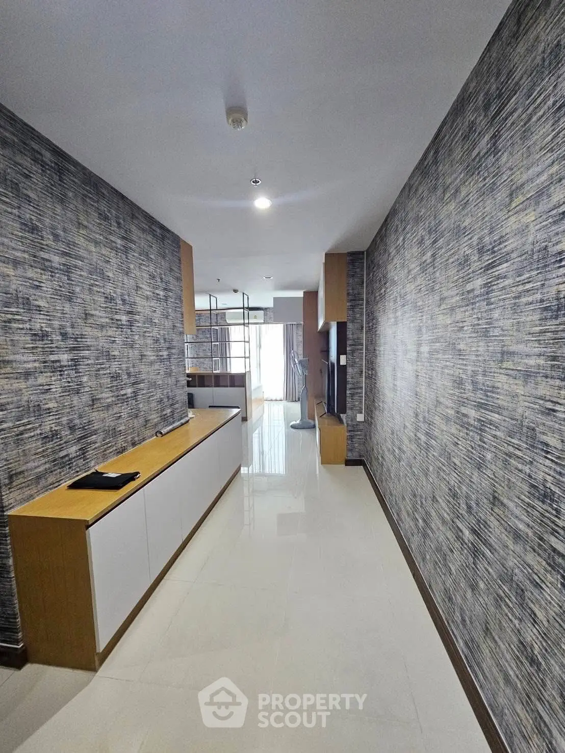 Modern hallway with stylish wallpaper and sleek storage unit in a contemporary home.