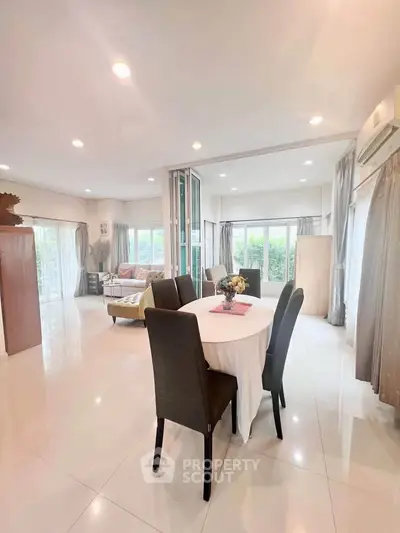 Spacious open-plan living and dining area with elegant decor and abundant natural light.