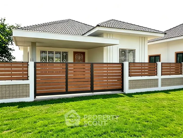 Charming modern house with stylish fence and lush green lawn, perfect for family living.