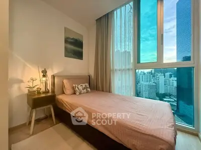 Cozy bedroom with city view, featuring a single bed and modern decor.