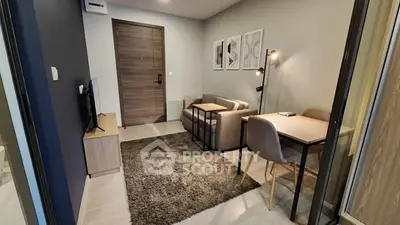 Modern living room with cozy sofa, TV, and stylish decor in a compact apartment.