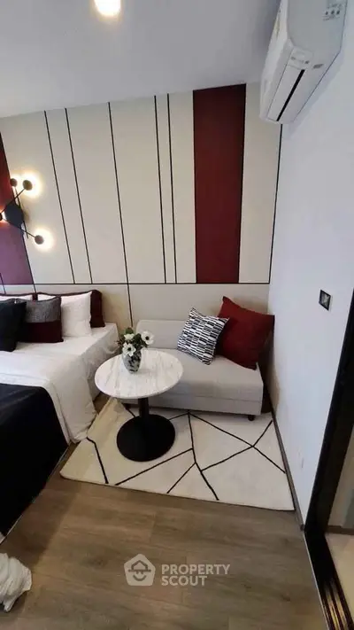 Modern bedroom with stylish decor and cozy seating area, featuring elegant lighting and contemporary design.