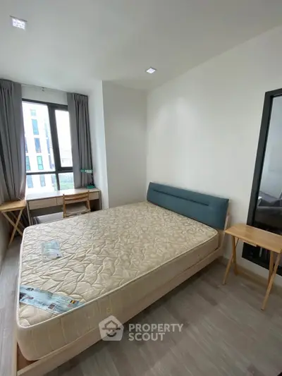 Modern bedroom with large window and minimalist furniture in a stylish apartment.