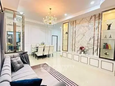 Luxurious living room with elegant chandelier and marble accent wall