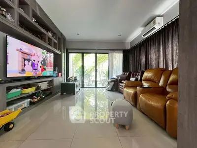 Spacious living room with modern decor and large TV, perfect for family gatherings.