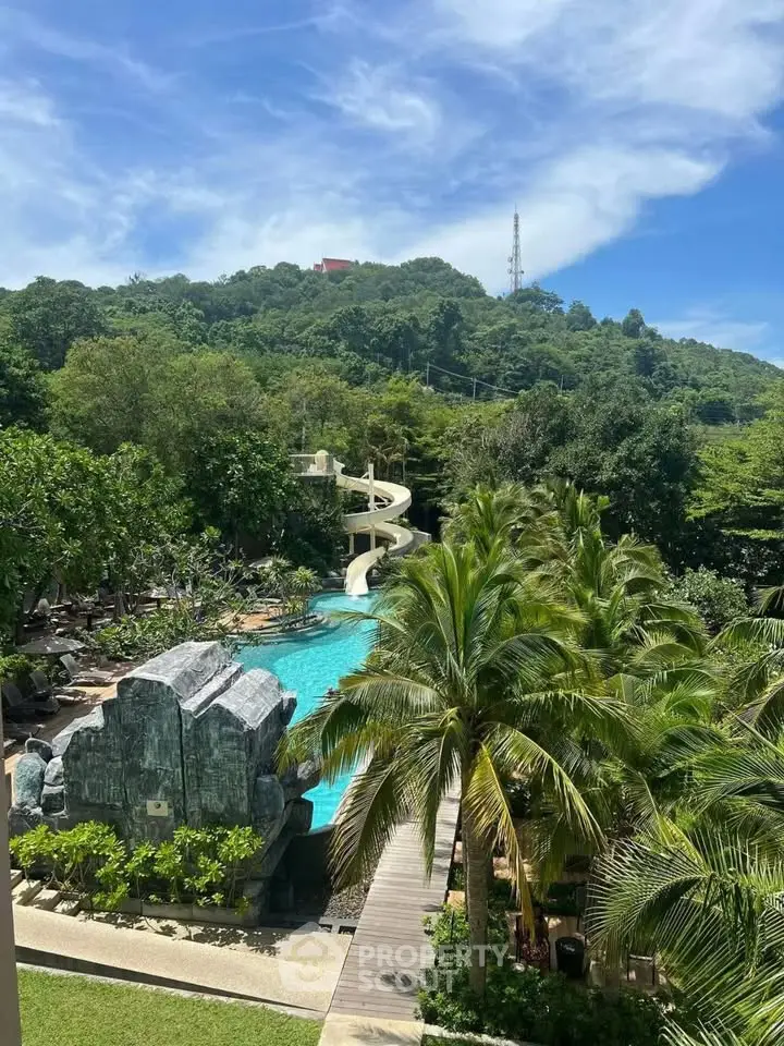 Luxurious resort-style pool with waterslide and lush greenery, perfect for relaxation and leisure.