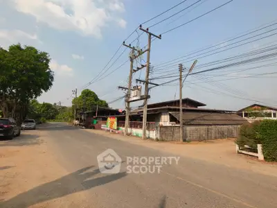 Charming rural street view with traditional houses and lush greenery, perfect for serene living.