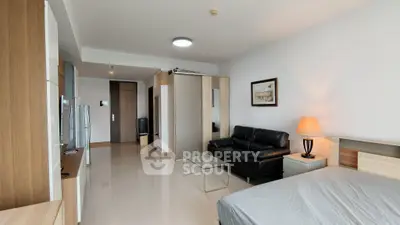 Modern studio apartment with sleek furnishings and open layout, featuring a cozy living area and stylish decor.