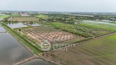 Expansive agricultural land with lush greenery and water bodies, ideal for farming or development.