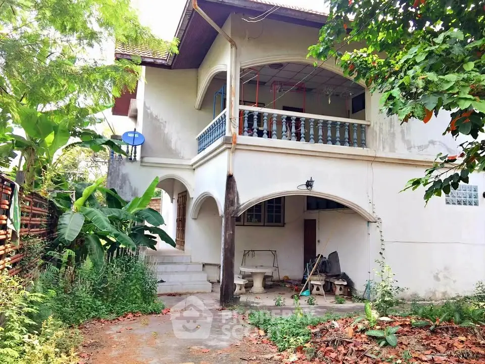 Charming two-story house with lush greenery and spacious balcony