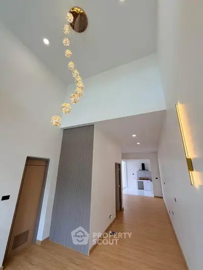 Spacious modern living room with high ceilings and elegant lighting fixtures.