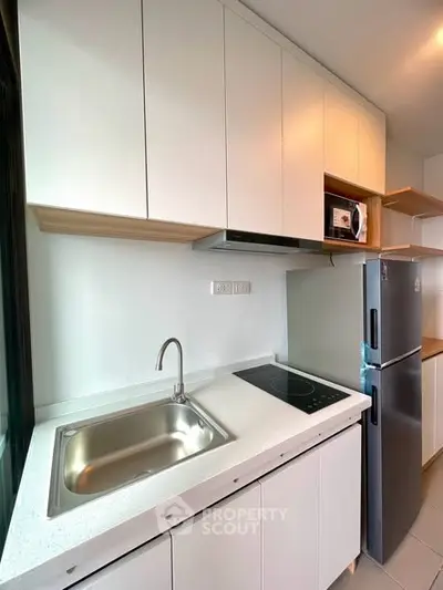 Modern kitchen with sleek white cabinets and stainless steel appliances