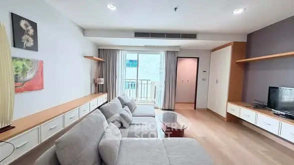 Spacious modern living room with large sofa and balcony access in a stylish apartment.