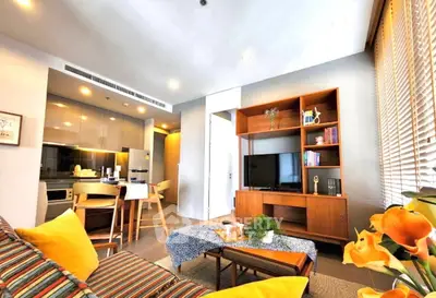 Modern living room with open kitchen, stylish furniture, and natural light