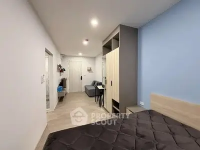 Modern bedroom with stylish decor and cozy seating area in a contemporary apartment.